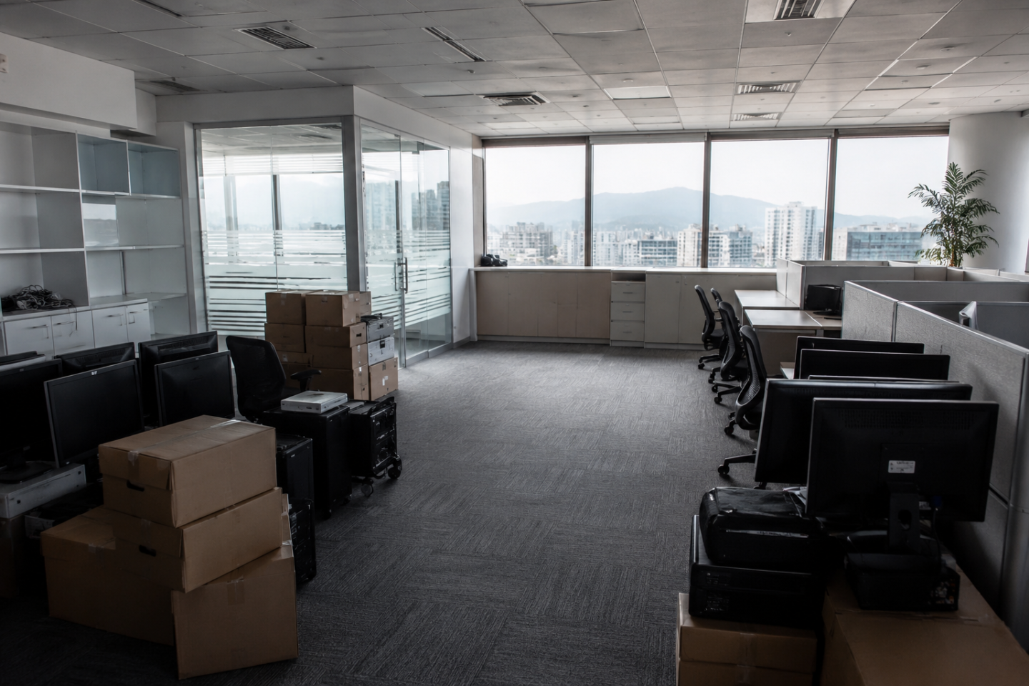 Empty office space with stacked computers, monitors and boxes prepared for professional IT equipment clearance in Taiwan.